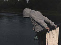 teen looks over edge of bridge