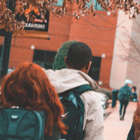 back of students walking wearing backpacks