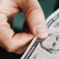 hand holding a five dollar bill