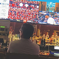 person at bar watching sports on multiple screens